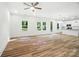 Open-concept living space with wood-look floors, a ceiling fan and an adjacent modern kitchen at 411 Patience Dr, Concord, NC 28025