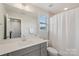 Bright bathroom features modern vanity with double sinks, large mirror, and shower with tile surround at 507 Yucatan Dr # 71, Waxhaw, NC 28173