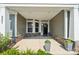 Inviting covered front porch with stone accents, gray siding, and well-manicured landscaping at 507 Yucatan Dr # 71, Waxhaw, NC 28173