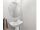 Simple yet elegant pedestal sink and mirror in a well-lit bathroom at 514 Bent Leaf Ct, Fort Mill, SC 29708