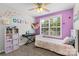 Bedroom with bright purple wall, shelving, rainbow bedding, and a keyboard at 514 Bent Leaf Ct, Fort Mill, SC 29708