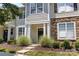 Close-up of a townhouse entrance featuring stone detailing, lush landscaping, and a welcoming walkway at 514 Bent Leaf Ct, Fort Mill, SC 29708