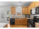 Bright and functional kitchen featuring light wood cabinets, black appliances, and plenty of counter space at 514 Bent Leaf Ct, Fort Mill, SC 29708