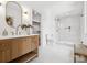 Modern bathroom with wood vanity, white countertop, glass enclosed shower and white tiles at 5311 Carmel Park Dr, Charlotte, NC 28211