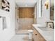 Modern bathroom with glass enclosed shower with gold fixtures and wood vanity with marble countertop at 5311 Carmel Park Dr, Charlotte, NC 28211