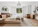 Bright bedroom featuring a large bed, a window, hardwood floors and decorative furnishings at 5311 Carmel Park Dr, Charlotte, NC 28211