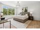 Bedroom featuring a large bed, hardwood floors, large window and modern decorative furnishings at 5311 Carmel Park Dr, Charlotte, NC 28211