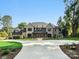 Stunning brick home featuring manicured lawns, a circular driveway, and classic architectural details at 5311 Carmel Park Dr, Charlotte, NC 28211