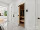 Bright hallway with access to a wooden sauna featuring glass doors and sleek white walls at 5311 Carmel Park Dr, Charlotte, NC 28211