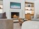 Modern living room with a fireplace and a TV above it, with open shelving and contemporary decor at 5311 Carmel Park Dr, Charlotte, NC 28211