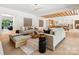 Bright and airy living room with modern furnishings and a seamless flow into the dining and kitchen area at 5311 Carmel Park Dr, Charlotte, NC 28211