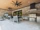 Covered outdoor kitchen and dining area featuring a built-in grill, stylish seating, and brick accents at 5311 Carmel Park Dr, Charlotte, NC 28211