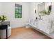 Stylish powder room featuring a floating marble countertop sink, wood floors and a window at 5311 Carmel Park Dr, Charlotte, NC 28211