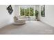 Bright sitting room featuring a comfortable chair, large windows with lush greenery, and modern decor at 5311 Carmel Park Dr, Charlotte, NC 28211