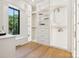 Bright walk-in closet features custom shelving, drawers, and a window overlooking the yard at 5311 Carmel Park Dr, Charlotte, NC 28211