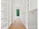 Spacious walk-in closet featuring custom shelving and drawers on each side of the window at 5311 Carmel Park Dr, Charlotte, NC 28211