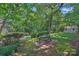 Lush backyard featuring a picnic table, brick patio and pathway, storage shed, and mature trees at 5441 Wintercrest Ln, Charlotte, NC 28209
