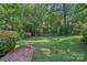 A large, well-maintained backyard with brick steps leading to a lush green lawn and privacy fence at 5441 Wintercrest Ln, Charlotte, NC 28209