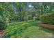 Large, lush backyard with mature trees, manicured lawn and landscape at 5441 Wintercrest Ln, Charlotte, NC 28209