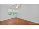 Empty bedroom showcases shiny wood floors and natural light streaming through the window, highlighting the room's spaciousness at 5441 Wintercrest Ln, Charlotte, NC 28209