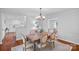 Cozy dining room featuring a wooden table, chandelier, and an open view to the kitchen and living room at 5441 Wintercrest Ln, Charlotte, NC 28209
