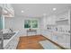 Bright kitchen with white cabinets, hardwood floors, and stainless steel appliances with a garden view at 5441 Wintercrest Ln, Charlotte, NC 28209
