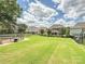 Large, well maintained backyard featuring green grass, mature trees, a trampoline and fenced perimeter at 7009 Providence W Ln, Charlotte, NC 28226