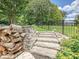 Stone steps and pathway that leads to the backyard with a fence and lush green grass at 7009 Providence W Ln, Charlotte, NC 28226