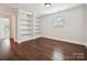 Bonus room with hardwood floors, built-in shelving, and a window for natural light at 7009 Providence W Ln, Charlotte, NC 28226