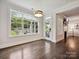 Cozy dining area featuring hardwood floors, large windows, and a view into the living room at 7009 Providence W Ln, Charlotte, NC 28226