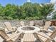 Entertaining outdoor space featuring a stone fire pit circled by Adirondack chairs on a stone paver patio at 7009 Providence W Ln, Charlotte, NC 28226