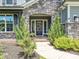 Elegant front door entrance with stone archway, manicured shrubs and beautiful architectural detail at 7009 Providence W Ln, Charlotte, NC 28226