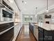 Well-lit, contemporary kitchen with stainless appliances, marble counters, dark cabinets, and an open layout at 7009 Providence W Ln, Charlotte, NC 28226