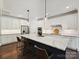Bright kitchen with white cabinets, stainless steel appliances, a marble countertop island with bar seating at 7009 Providence W Ln, Charlotte, NC 28226