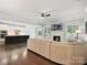 Open-concept living room featuring hardwood floors, a fireplace, and a kitchen island with seating at 7009 Providence W Ln, Charlotte, NC 28226