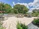 Inviting stone patio with outdoor kitchen, wood burning, and seating area, ideal for entertaining with a lush landscape surround at 7009 Providence W Ln, Charlotte, NC 28226