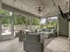 Inviting screened-in patio with comfortable seating, a ceiling fan, and views of the serene backyard space at 7009 Providence W Ln, Charlotte, NC 28226