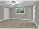 This bedroom features a neutral wall color, carpet, ceiling fan, and a window at 7032 Waxhaw Hwy, Lancaster, SC 29720