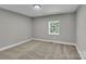 A bedroom features neutral walls, carpet, and a window providing natural light at 7032 Waxhaw Hwy, Lancaster, SC 29720