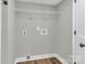 This laundry room features connections for a washer and dryer, a wire rack, and wood-look floors at 7032 Waxhaw Hwy, Lancaster, SC 29720