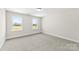 Bright bedroom featuring carpeted floors and two large windows offering scenic views at 925 Marys Grove Rd, Cherryville, NC 28021