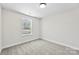 A bedroom with a window that provides natural light and neutral wall-to-wall carpeting at 925 Marys Grove Rd, Cherryville, NC 28021