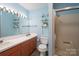 Bright bathroom with dual sinks, a shower stall, and glass shelving at 938 Kannapolis Pkwy, Concord, NC 28027