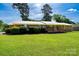 Charming brick home with a well-manicured lawn, lush greenery, and a welcoming front porch at 938 Kannapolis Pkwy, Concord, NC 28027