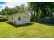 Detached garage with a fresh white door, complemented by a well-manicured lawn and vibrant garden at 938 Kannapolis Pkwy, Concord, NC 28027