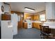 Functional kitchen with wooden cabinets, white appliances, and a cozy breakfast bar area at 938 Kannapolis Pkwy, Concord, NC 28027