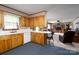 Kitchen showcasing wooden cabinets, a white countertop and breakfast bar, seamlessly connects to the living room at 938 Kannapolis Pkwy, Concord, NC 28027