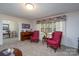 Bright living area with armchairs, large windows, and a piano for relaxation and entertainment at 938 Kannapolis Pkwy, Concord, NC 28027