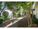 Landscaped backyard featuring a walkway to the patio with pergola and fire pit at 9644 Marquette Nw St, Concord, NC 28027
