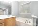 Comfortable bathroom featuring a soaking tub and a large window at 9644 Marquette Nw St, Concord, NC 28027